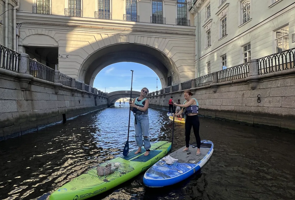 Участники на SUP-досках под городским мостом