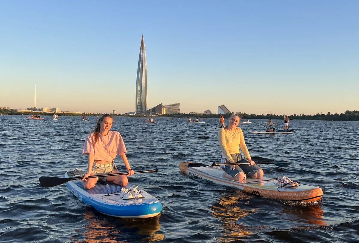 Участницы SUP-прогулки на фоне Лахта Центра